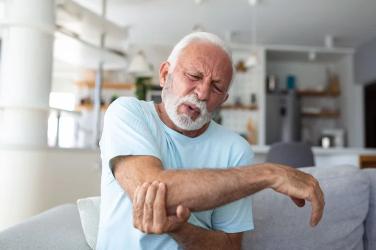Older adult using an adaptive approach to a daily activity while managing arthritis