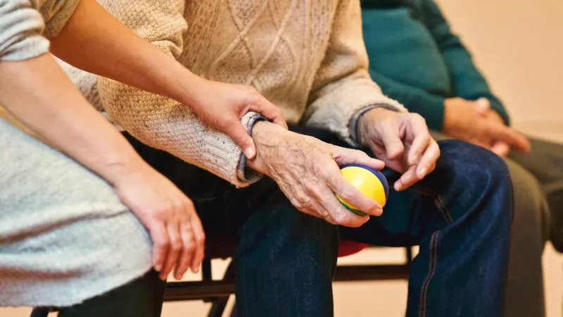 Caregiver holding an elderly person's hand, representing the emotional bond and stress of caregiving