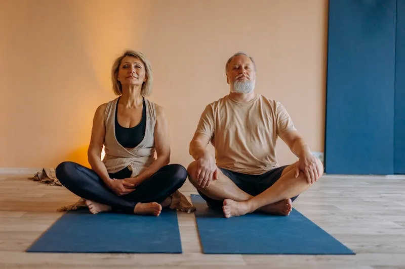 Elderly couple doing yoga together, representing lifestyle management strategies for bipolar disorder in seniors