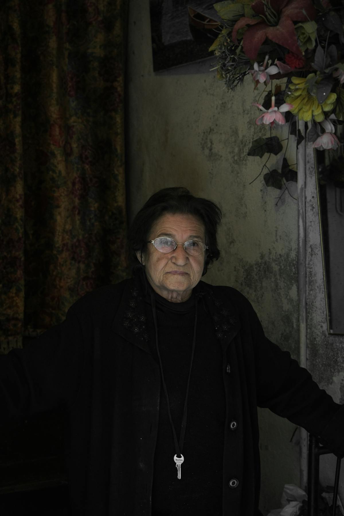 Senior woman sitting in a softly lit room during evening, illustrating the time of day when sundowning symptoms often occur